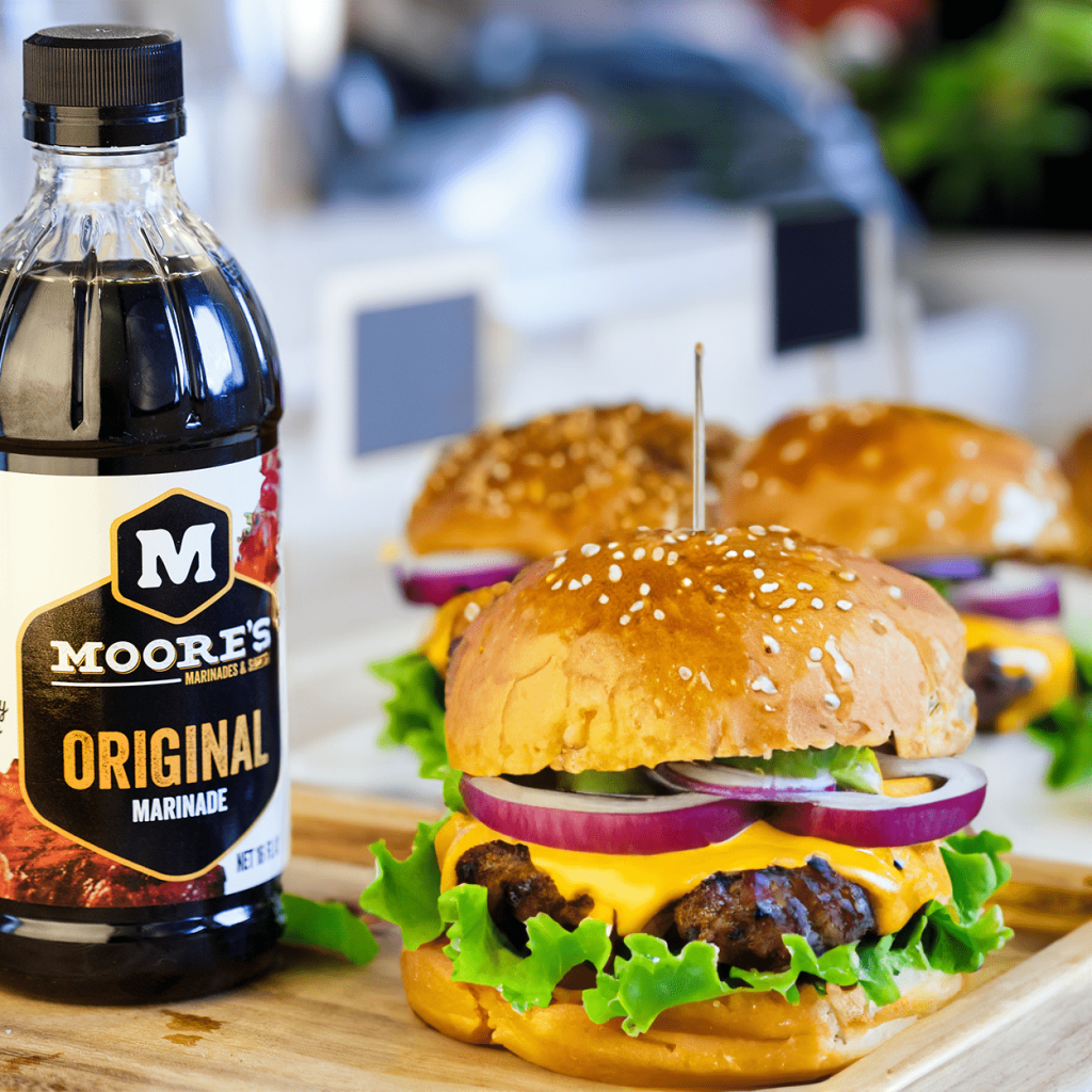CPG marketing image featuring Moore’s Original Marinade next to cheeseburgers on a wooden board