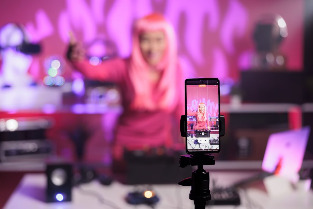 CPG TikTok advertising influencer recording a viral video in a vibrant pink setup, showcasing branded content engagement.