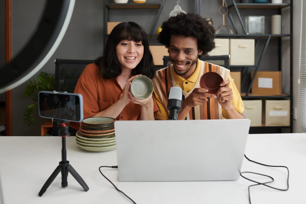Two UGC creators filming a product review on a phone — the authentic content that fuels UGC for CPG brands