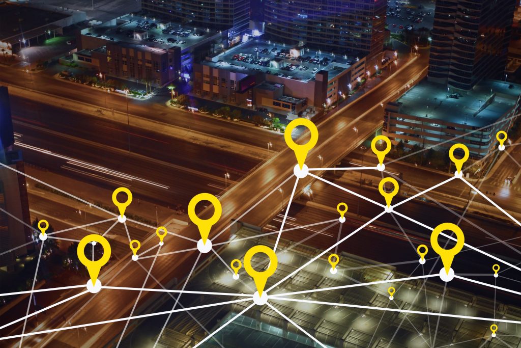 Map pins marking retail store locations across a city at night, illustrating product launch geotargeting